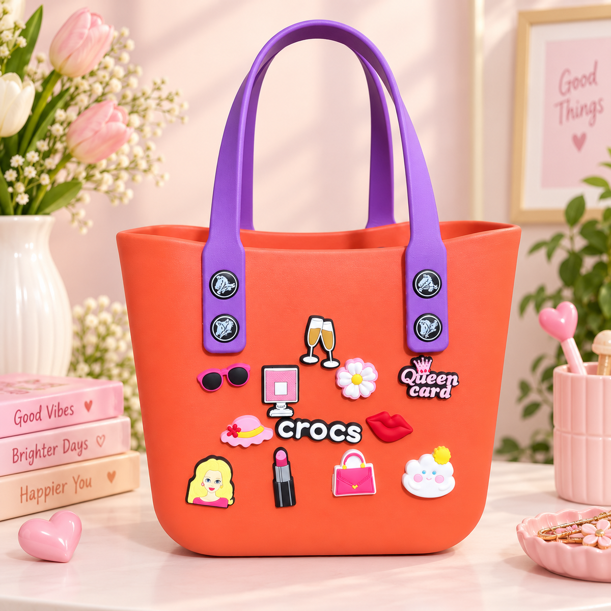 Coral orange Crocs-style tote bag with purple handles and colorful decorative charms displayed in a cute pastel setting