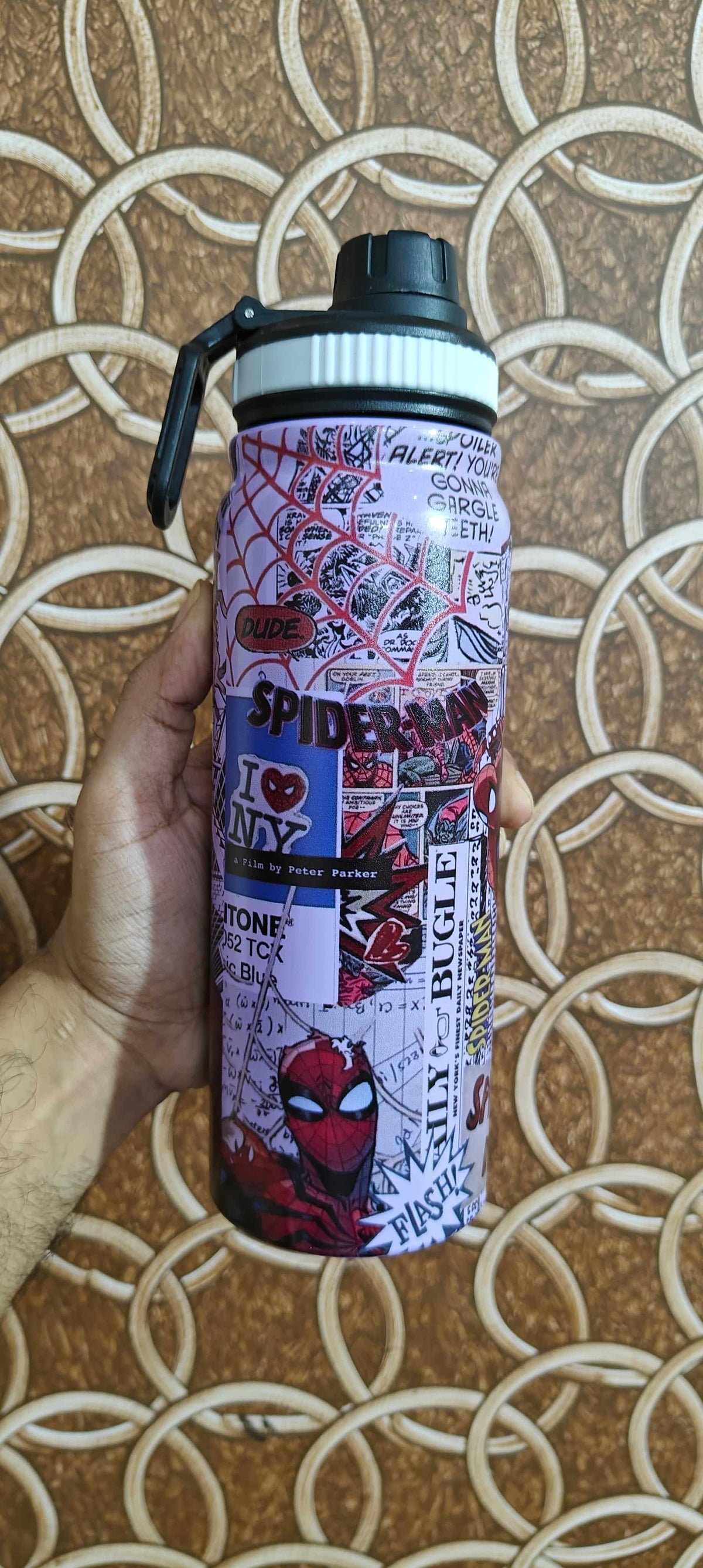Hand holding a Nestspidy 800ML insulated water bottle with a Spider-Man comic print design